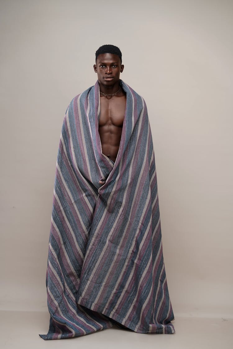 A Ma Draped In Striped Blanket