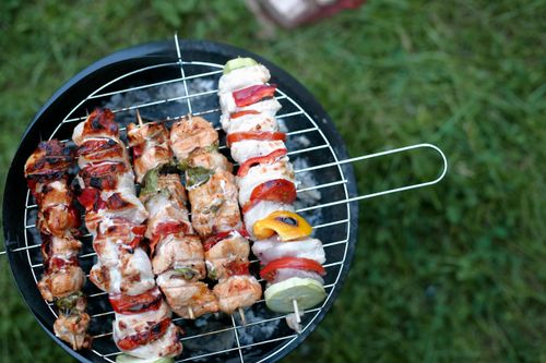 Free Close-up view of colorful chicken skewers on a charcoal grill. Stock Photo