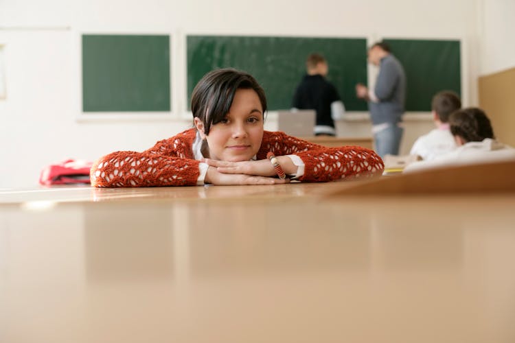 Girl Lying On Desk In School