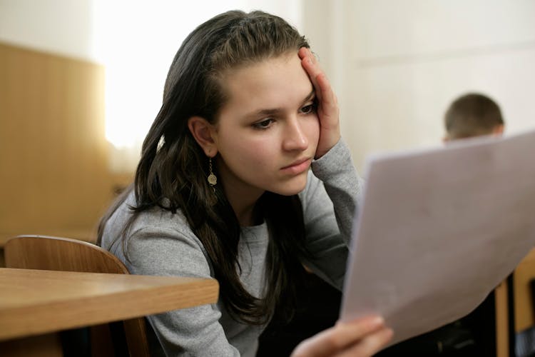 Young Woman Holding And Reading A Document 