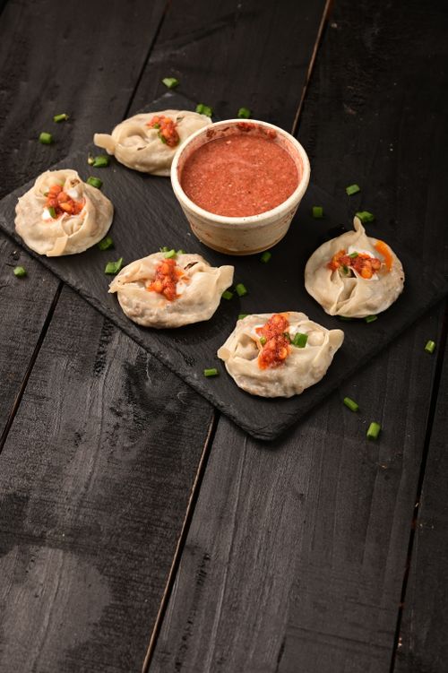 Free High angle view of dumplings with spicy sauce on a slate tray, perfect for a tasty meal. Stock Photo