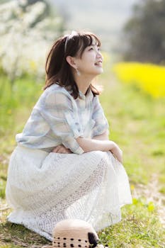 一位穿着白色连衣裙的女子在公园里微笑，享受着阳光明媚的一天