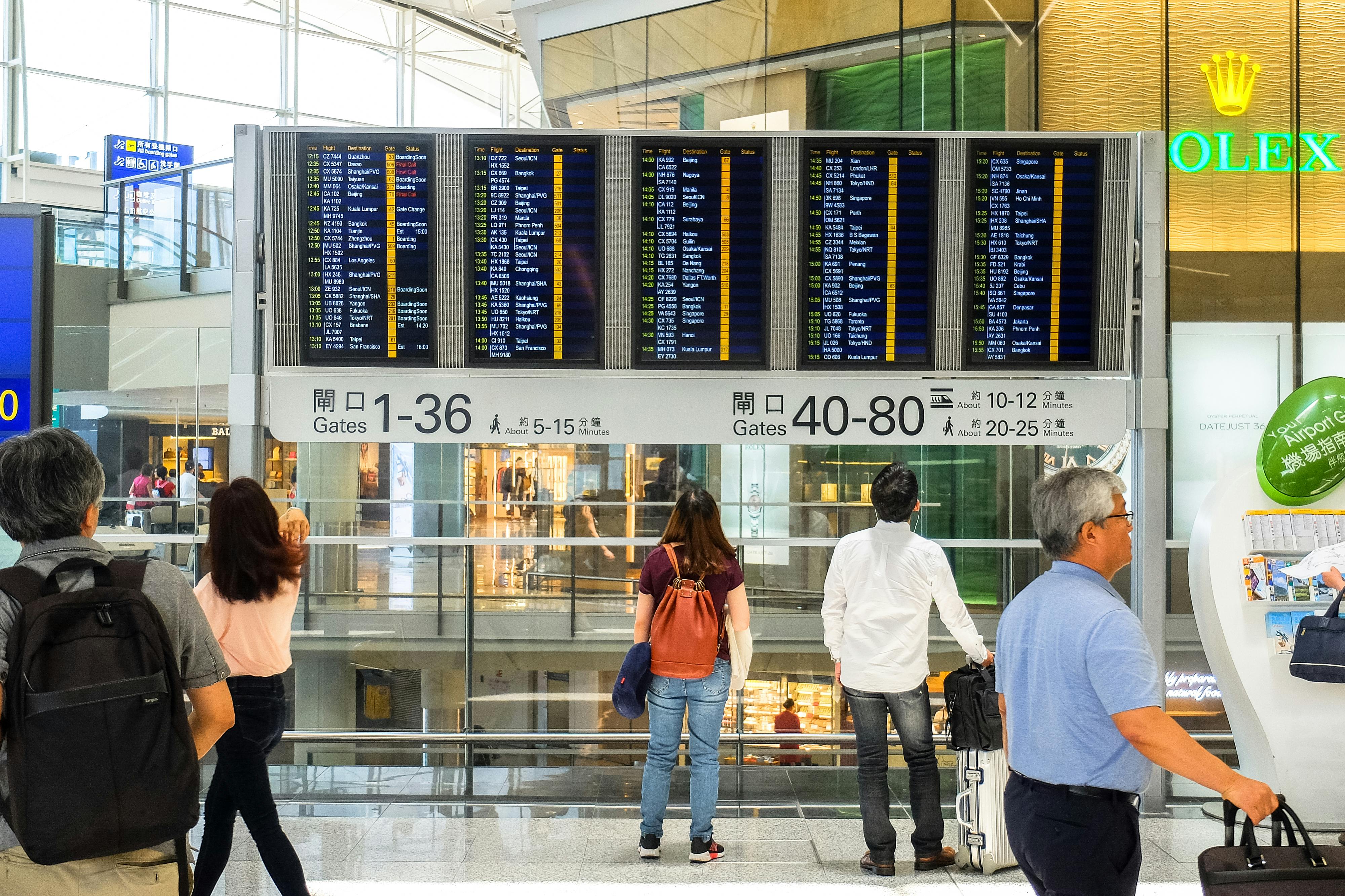 Free People Standing Near Airport Departure Board Stock Photo