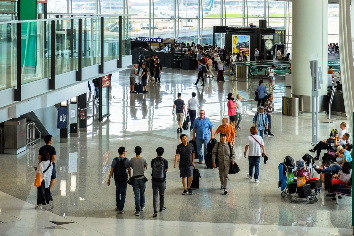 Passengers with luggage in an airport terminal; illustrative image, not Port Blair airport