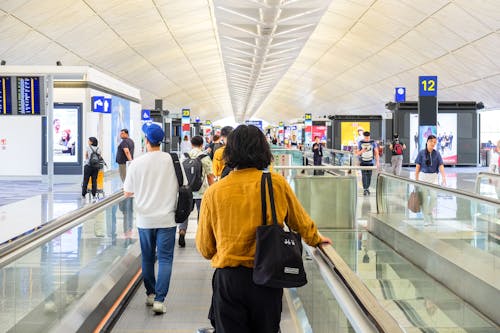 View of a Busy Airport Building with People Walking around with Luggage 