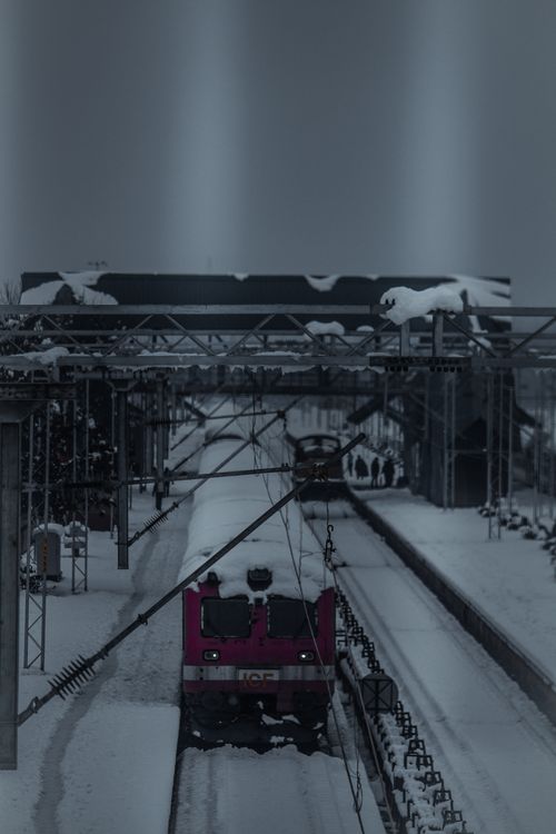 Free A train arrives at a snow-covered station in Mirgund, showcasing winter transportation. Stock Photo