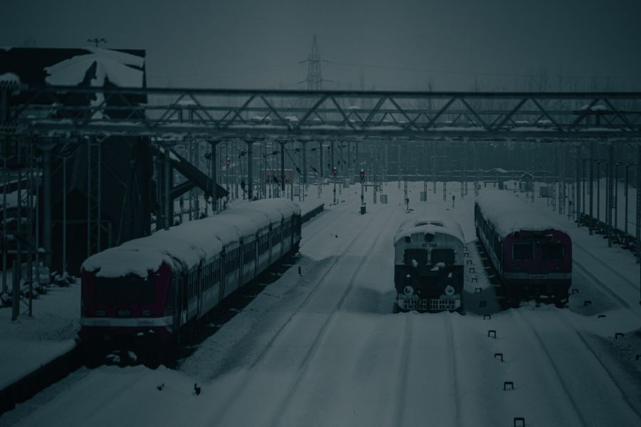 Snow-covered trains at Mirgund railway station during winter in Kashmir.