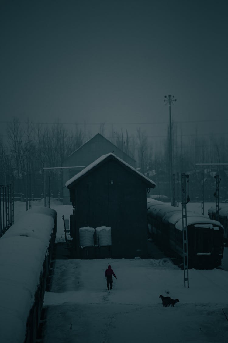 View Of A Building Between Trains At A Station Covered In Snow 