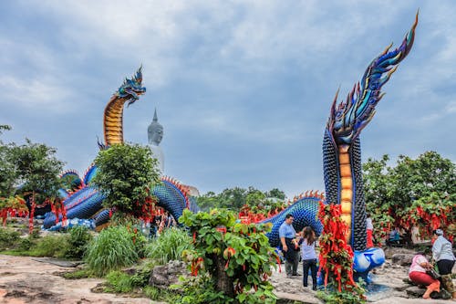 People Roaming Around Near Blue Dragon Monument