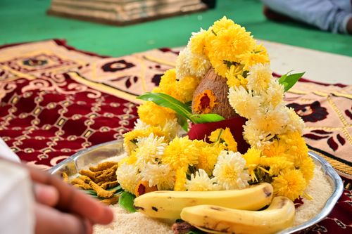 Free Close-up of a traditional Indian wedding ritual setup featuring bananas, coconuts, and flower garlands on an ornate carpet. Stock Photo