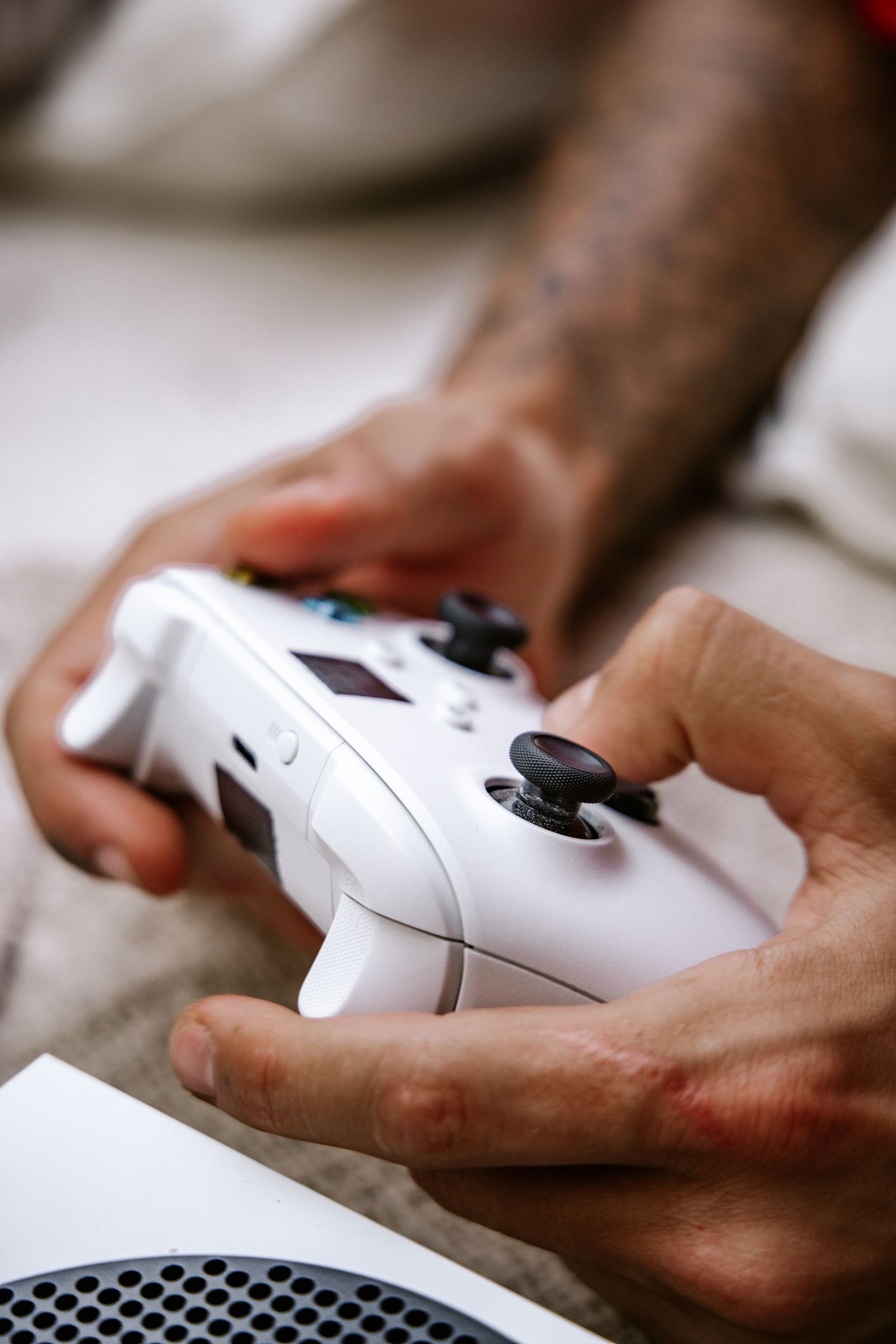 Hands holding a white gaming controller during a gaming session