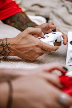 Hands gripping game controllers in an intense gaming session, focus on tattooed arms.