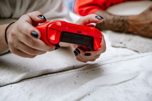 Close-up of hands holding a red game controller, perfect for gaming and technology themes.