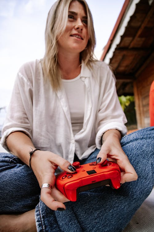 A Woman Holding a Red Video Game Controller