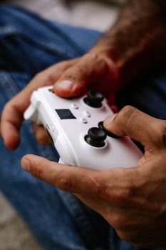 Detailed view of hands holding a white gaming controller, showcasing gaming action.