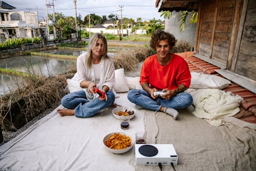 Man and Woman Playing Video Game Outdoors