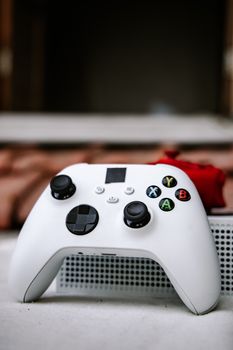 Close-up view of a white gaming controller on a console, ideal for gaming enthusiasts.
