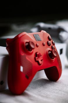 Close-up of a red gaming controller on a console, perfect for video game enthusiasts.