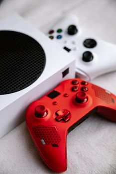 Close-up of a red gaming controller and a white console, perfect for showcasing gaming setups.