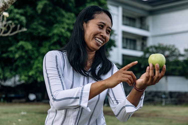 A Woman Holding An Apple