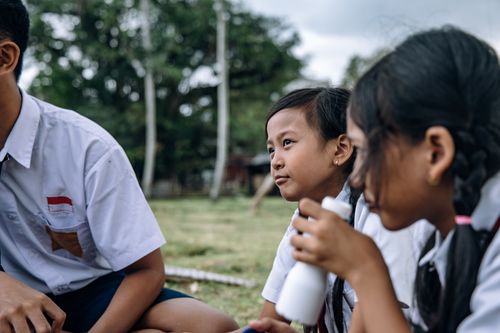 Free Group of cheerful children enjoying a lively outdoor school gathering in uniform. Stock Photo