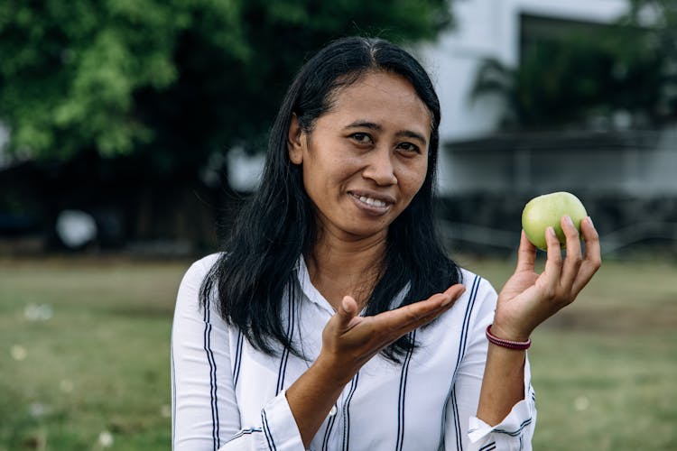 A Woman Holding An Apple