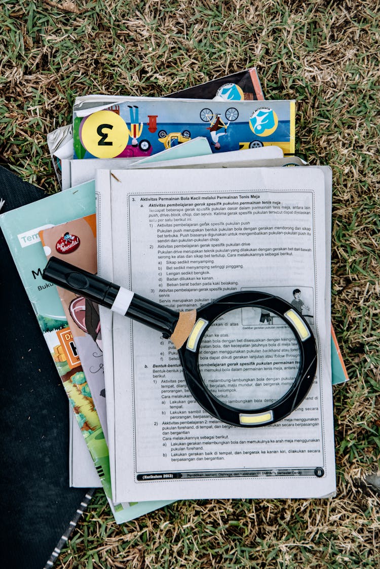 Close-Up Shot Of A Magnifying Glass On Top Of Books