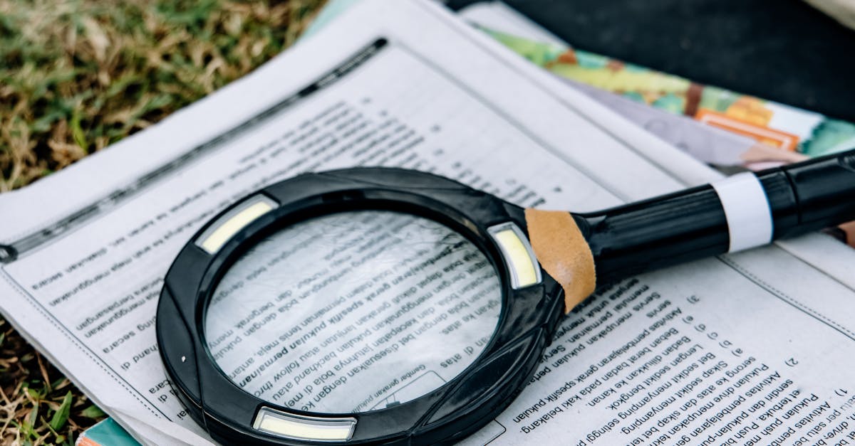 A magnifying glass rests on papers outdoors, suggesting research or reading.