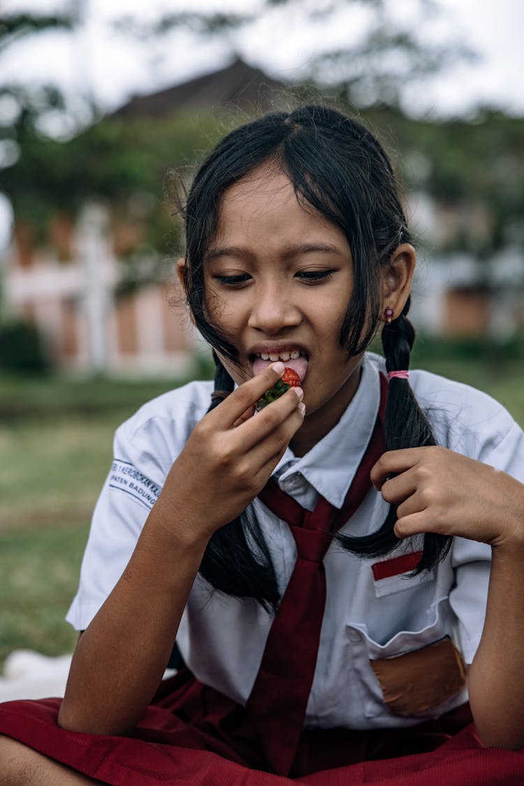 A Female Student Sitting On A Grassy Field