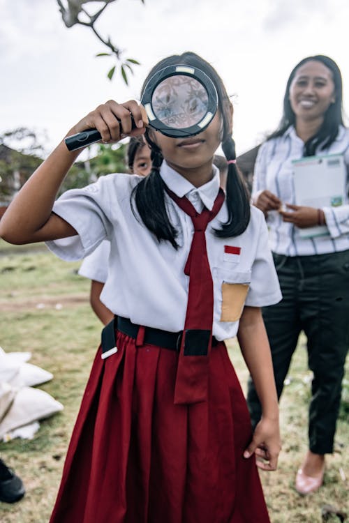 A Female Student Holding a Magnifying Glass