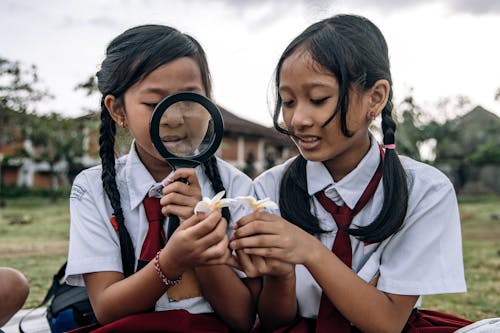 Two Students Using a Magnifying Glass