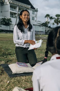 A teacher engages with students in an outdoor class setting, fostering a positive educational environment.