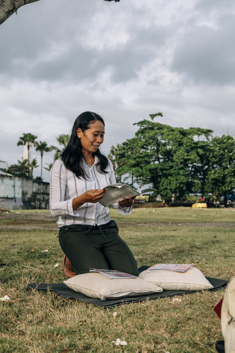 A Woman In White Top Holding A Book