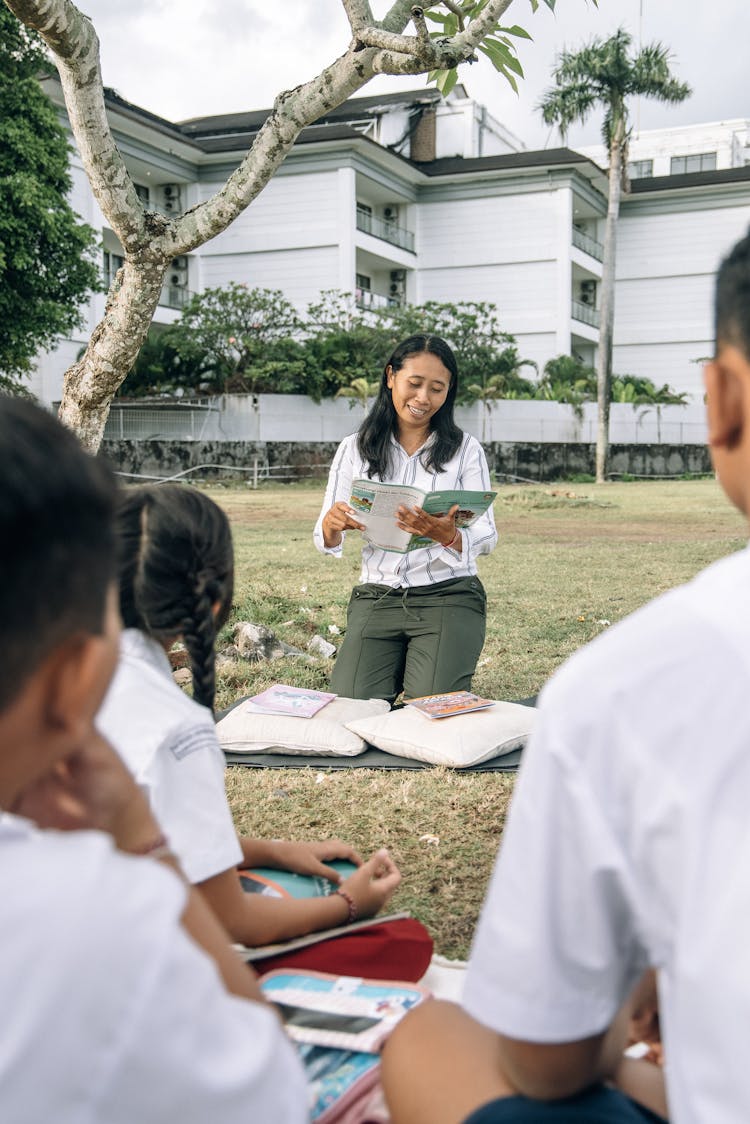 A Woman In White Top Holding A Book