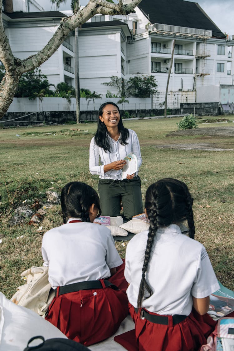 Teacher And Students Having Class Outdoors