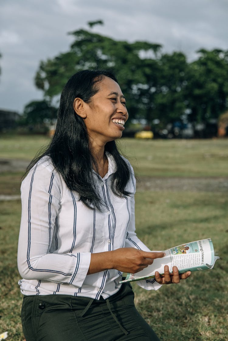 A Woman In White Top Holding A Book