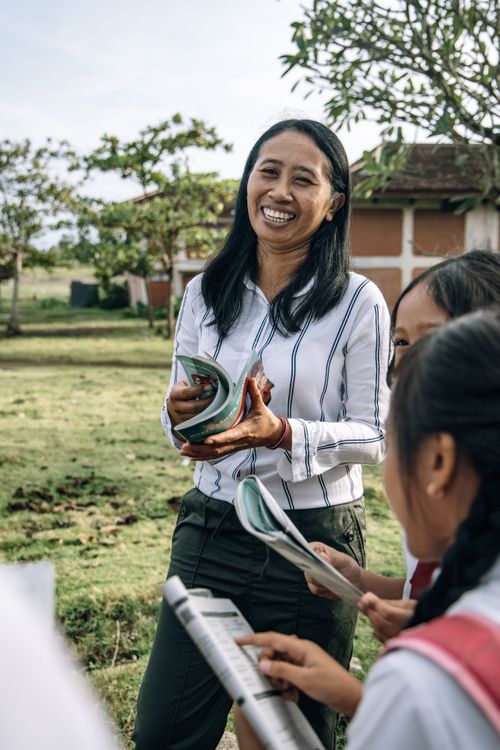 Free A joyful teacher interacts with students during an outdoor lesson, fostering a love for learning. Stock Photo