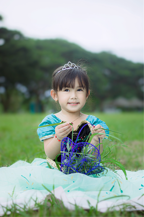 A Girl in Blue Dress Sitting on Green Grass Field · Free Stock Photo