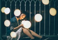 夜晚，年轻女子在柔和的灯光下享受艺术散景效果