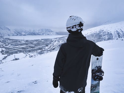 Back View of a Man Standing with Snowboard