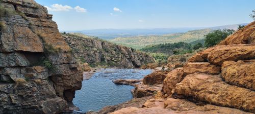 Free Scenic view of a rocky river canyon in Rustenburg, South Africa with lush greenery. Stock Photo