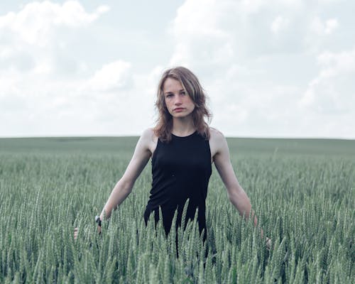 A Woman in Black Dress Standing on Wheat Field