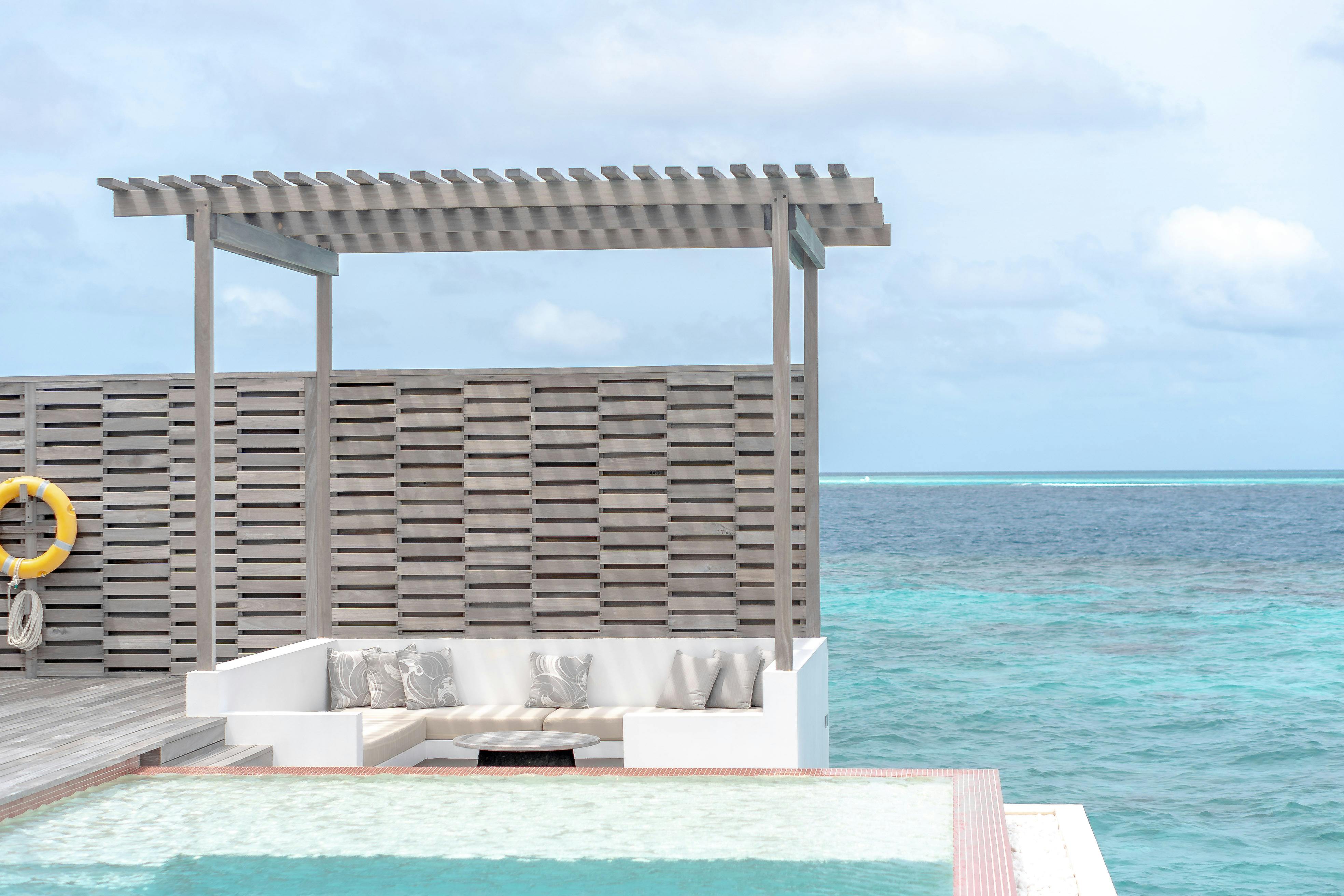 Luxurious beachfront cabana overlooking the turquoise ocean, perfect for relaxation in a tropical paradise.