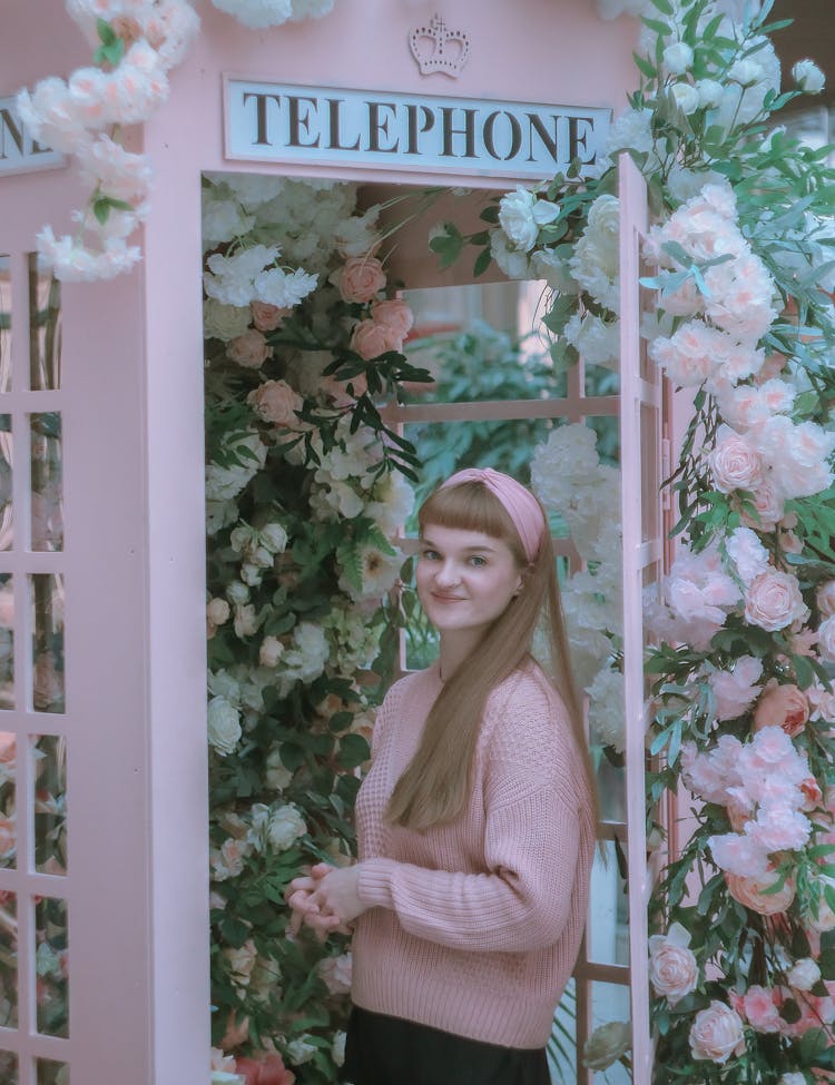 Young Woman In A Telephone Booth Decorated With Flowers