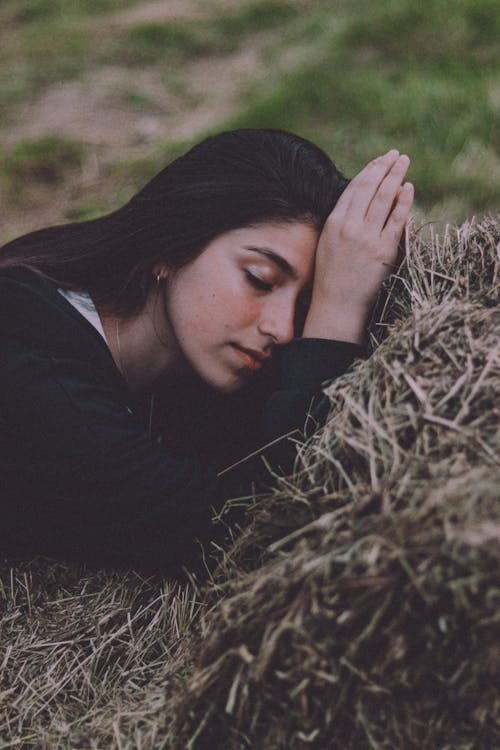 Woman Lying on Bale of Hay