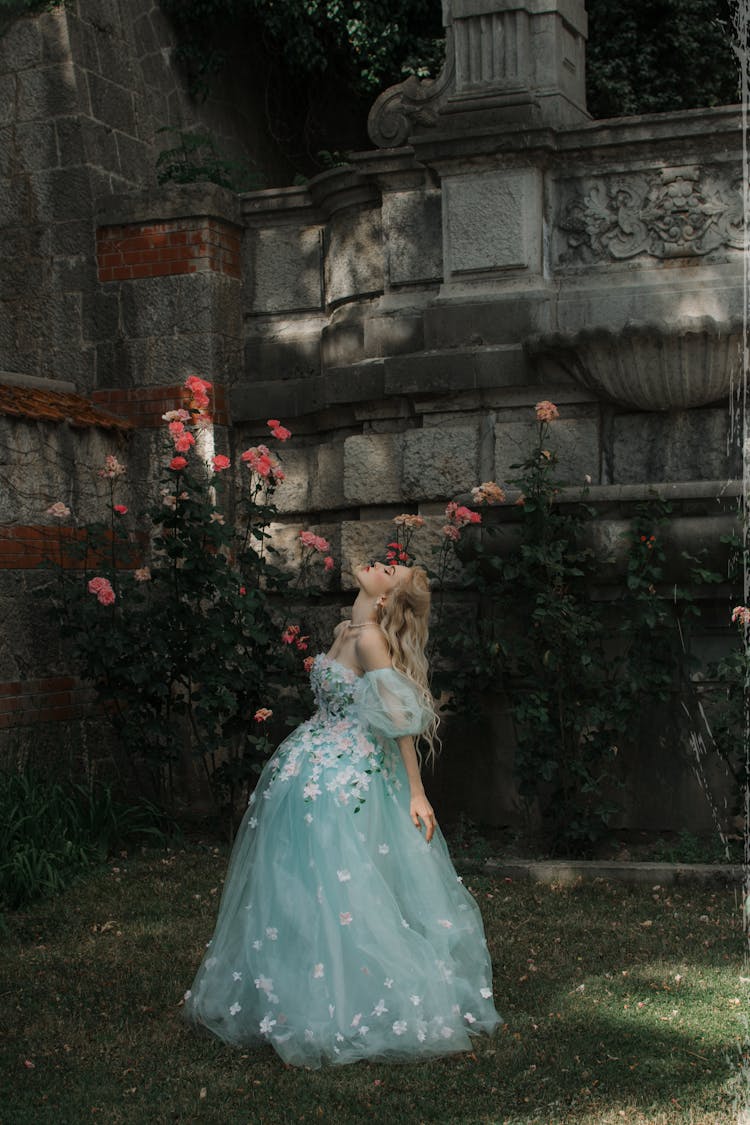 Woman In Princess Gown Walking Through Garden