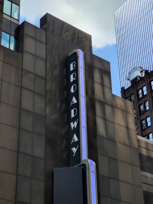 Free Iconic Broadway sign in NYC amidst skyscrapers, perfect for urban and theater themes. Stock Photo