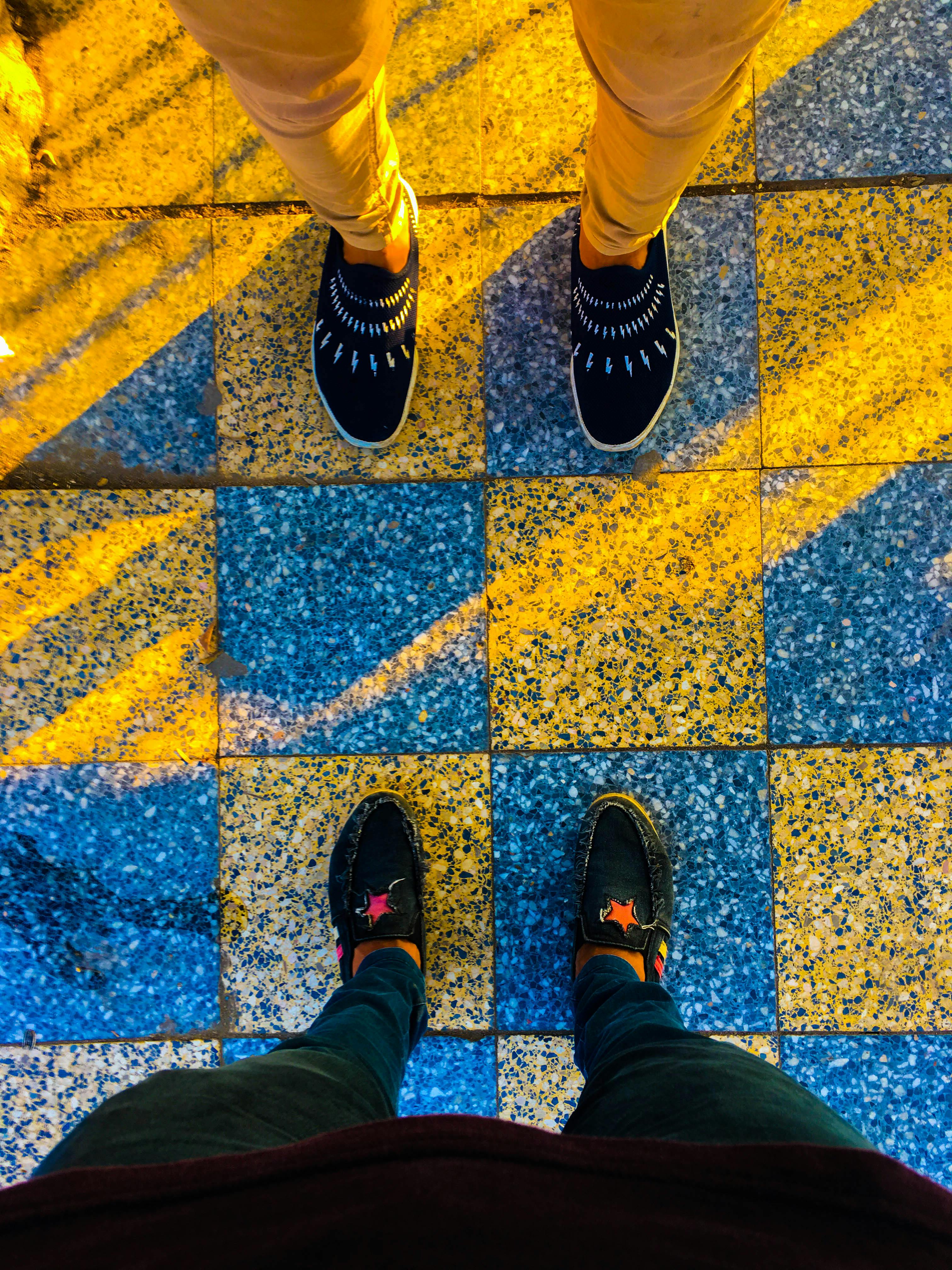 彩色格子瓷砖的顶视图与两双时尚鞋子形成了鲜明对比