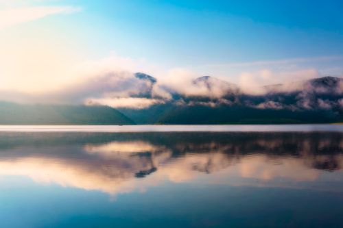 Free Tranquil scene of Eagle Nest Lake with misty mountains reflecting on the water. Stock Photo