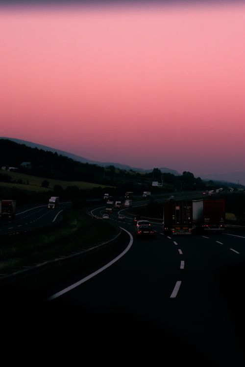 Free Peaceful drive on a highway during sunset with stunning sky hues and open road. Stock Photo